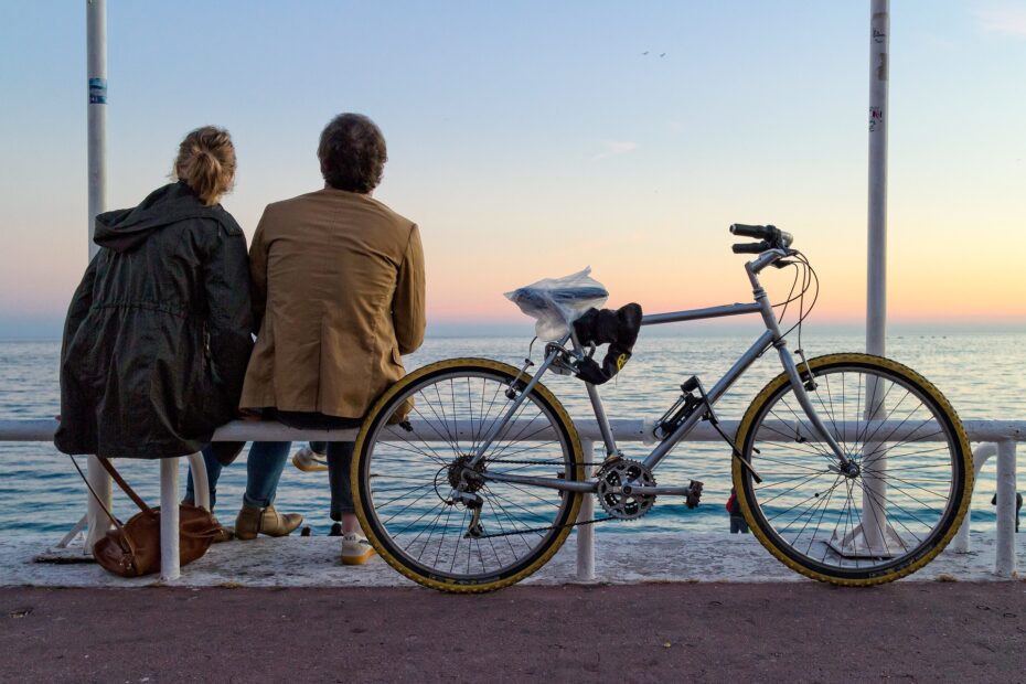 Ett par som tittar på solnedgången tillsammans med en cykel. Cykelrum och tvåvånings cykelställ med cykellift för en säkrare förvaring av dina hyresgästers alla cyklar.